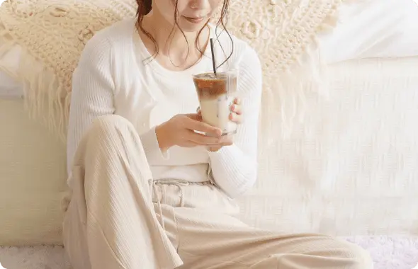 グラスに入っているソイラテを飲む女性の写真